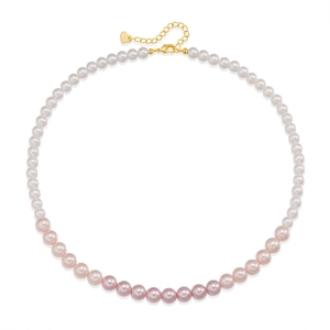 Detail van tweekleurige parels met verstelbare gouden ketting en hartbedel