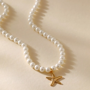 Macro-opname van een gouden zeester hanger aan een elegante witte parelketting