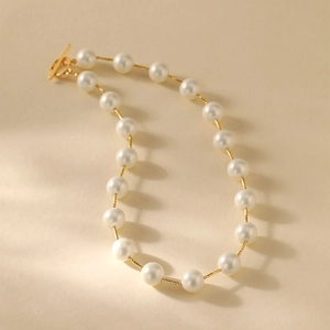 Detail van een vintage handgemaakte parelketting met gouden kneelsluiting en witte schelpen
