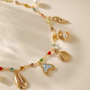 Bohemian 18K gold plated anklet with sea shells and ocean charms on minimalist background