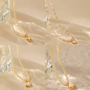 Vintage parelkettingen met onregelmatige witte schelphangers en goudkleurige monturen
