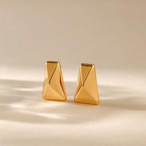 Macro detail of geometric 18K gold plated brass stud earrings with irregular texture