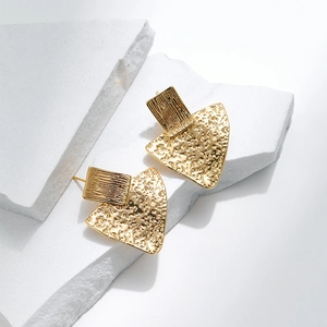 Detail of 18K gold plated earrings with brushed rectangle and hammered texture fan charm