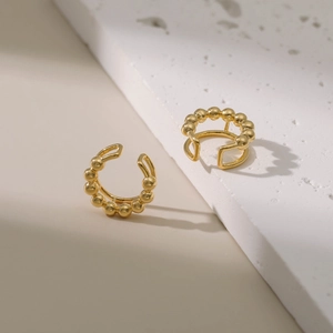 Manchettes d'oreilles dorées en C avec perles minimalistes sur surface en pierre