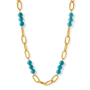 Détail d'un collier bohème doré avec perles turquoise sur fond blanc épuré