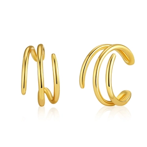 Gros plan de boucles d'oreilles spirales dorées multicouches avec finition polie sur fond blanc