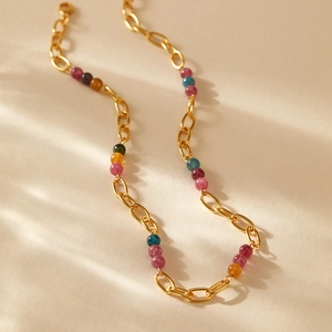 Détail macro du collier perlé plaqué or 18K avec pierres multicolores et fermoir mousqueton