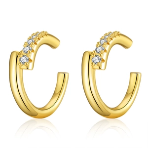 Détail de boucles d'oreilles créoles dorées en C avec pavé de zircons blancs étincelants