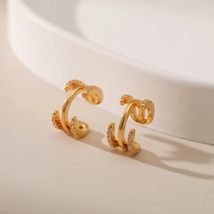 Vue détaillée des boucles d'oreilles C dorées ornées de micro-oxydes de zirconium brillants