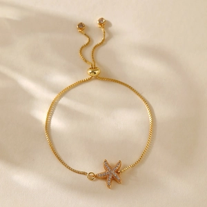 Detail of gold starfish bracelet with pavé zircons and adjustable slider clasp