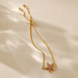 Detail of a 18K gold plated starfish bracelet with sparkling zircon pavé and adjustable slide clasp