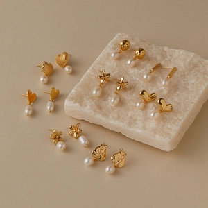 Flachbildaufnahme von Vintage-Ohrringen mit Goldbeschichtung, Perlen und Herz-Blumen-Design