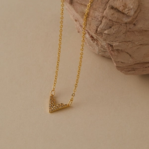 Dettaglio di una collana placcata in oro 18K con pendente a V e zirconi lucenti incastonati