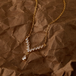 Dettaglio della collana placcata oro 18K con zirconi a V e ciondolo a forma di pera