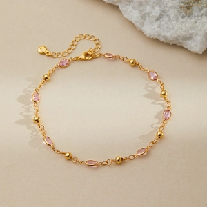 Detail of 18K gold plated anklet featuring pink oval stones and adjustable lobster clasp