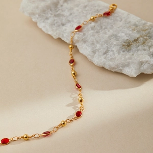 Detail of 18K gold plated anklet with vintage red oval gems and small round beads