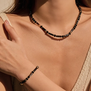 Ensemble élégant de collier et bracelet en onyx noir avec accents dorés sur modèle