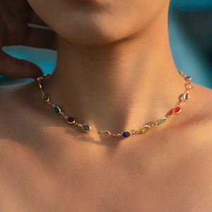 Exotische gouden dopamine ketting met gekleurde ovale edelstenen gedragen door model