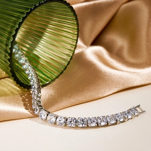 Detailed macro view of a silver tennis bracelet with sparkling diamonds on luxury silk