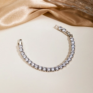 Close-up of elegant tennis bracelet with cubic zirconia set on golden silk fabric