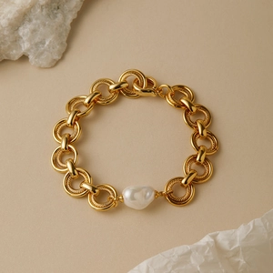 Dettaglio del bracciale con perla barocca placcata oro e catena a maglie intrecciate