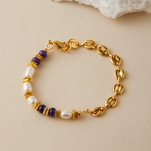 Dettaglio del bracciale con perle, catena dorata e inserti in pietre naturali viola