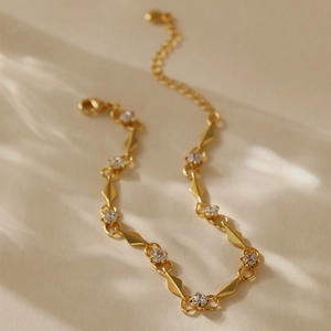Makroaufnahme einer 18K vergoldeten Kette mit geometrischen Gliedern und Karabinerverschluss