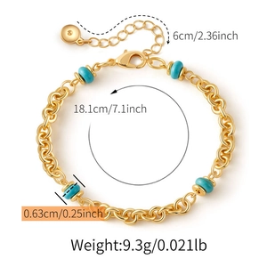 Dettaglio del bracciale a catena dorata con perle turchesi e chiusura a moschettone