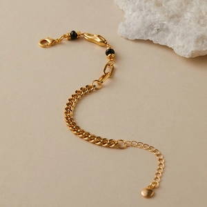 Elegante bracciale a catena placcato oro 18K con perline nere su sfondo strutturato