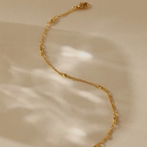 Detail der 18K vergoldeten Kette mit diamantgeschliffenen Metallperlen und Karabiner