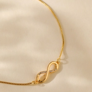 Detail of infinity pendant with micro-set zircons on a gold-plated box chain