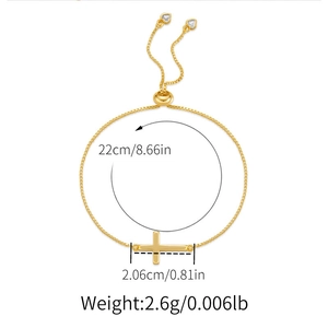 Detail showing adjustable gold cross bracelet with heart bead slider and chain dimensions
