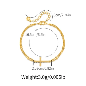 Detailed view of gold chain bracelet with cross pendant and adjustable lobster clasp closure