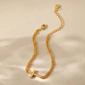 Detail of double-layer gold plated cross bracelet with adjustable lobster clasp and chain