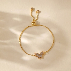 Detailed view of gold plated adjustable bracelet with pavé butterfly charm and crystals