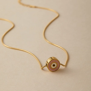 Dettaglio della collana a catena serpente dorata con ciondolo Evil Eye in smalto rosa