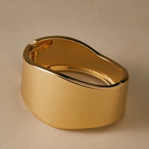Detailed side view of wide gold hinged cuff bangle with elegant matte satin finish