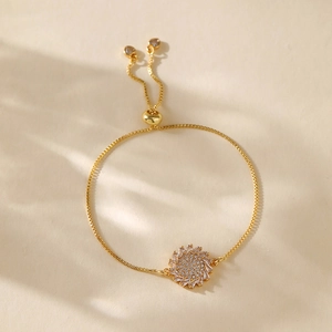 Detail of gold-plated sun flower bracelet with zircons and adjustable heart drawstring