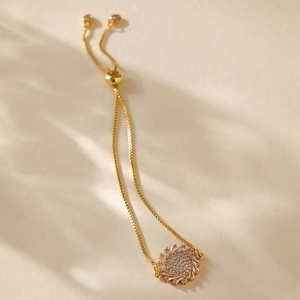 Detailed macro view of gold plated sunflower bracelet with adjustable slider and cubic zirconia
