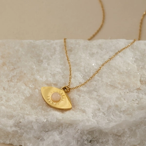 Dettaglio della collana placcata in oro con malocchio e pietra preziosa rosa
