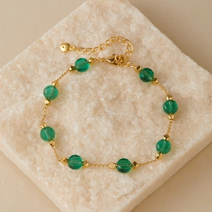 Detail view of 18K gold plated chain with green faceted glass beads and adjustable lobster clasp