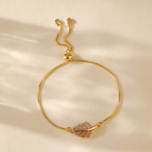 Detail of gold leaf charm bracelet with cubic zirconia inlay and adjustable box chain