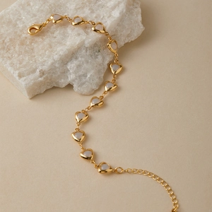 Detailed macro view of heart-shaped gold-plated chain links with mother of pearl inlays