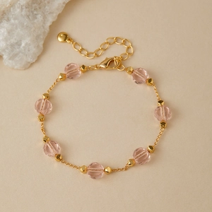 Detail of pink faceted glass beads on a gold-plated adjustable chain bracelet