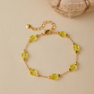 Macro detail of 18K gold-plated chain with yellow faceted beads and lobster clasp closure