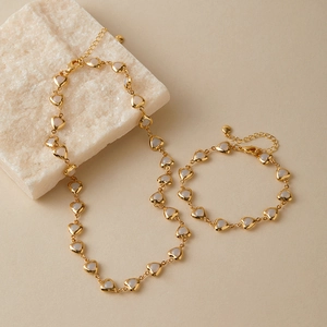 Detail view of 18K gold plated jewelry set with white heart charms and lobster clasp