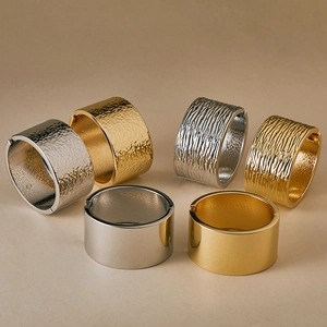 Detail of wide metal bangles in gold and silver with hammered and wave textures
