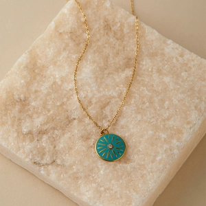 Dettaglio della collana dorata malocchio su pietra con ciondolo sole in smalto blu vibrante