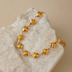 Detailed macro view of 18K gold plated heart bracelet with bright yellow resin inlay