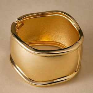Macro view of gold wide cuff bracelet with irregular wavy edges and hammered inner texture
